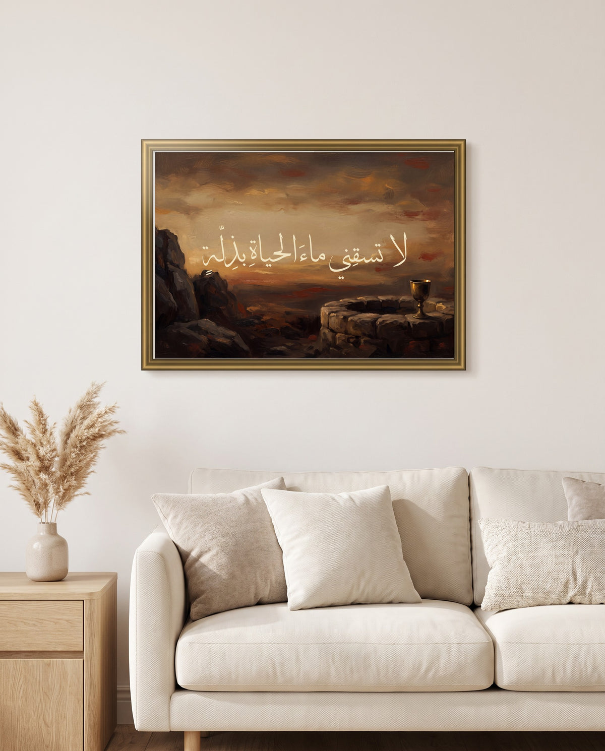 Not the Water of Life with Humiliation: Arabic poetry in Thuluth calligraphy, framed in polished gold above a cream sofa in a living room