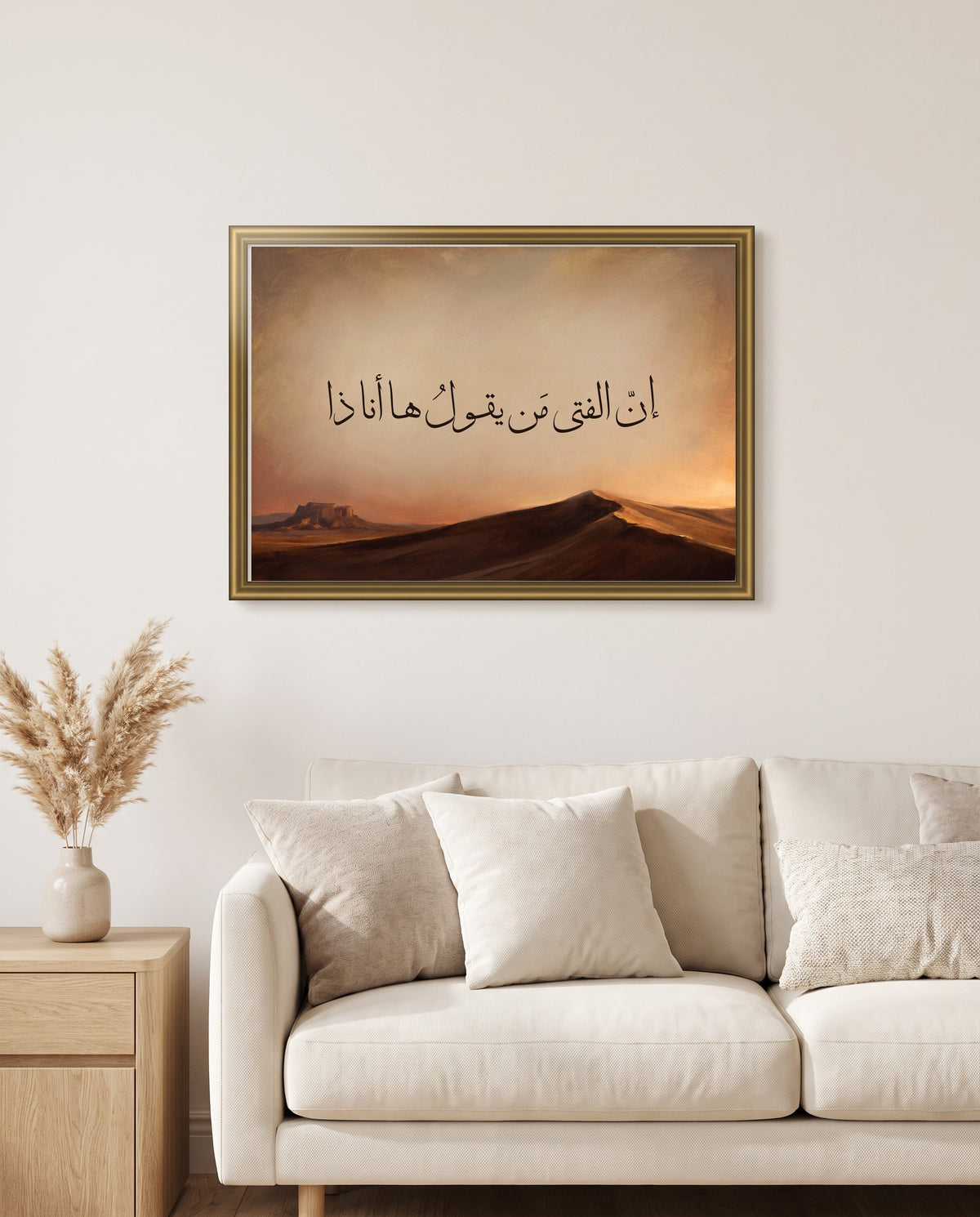 «إن الفتى من يقول ها أنا ذا» بخط الثلث في إطار ذهبي مصقول فوق أريكة كريمية في غرفة الجلوس