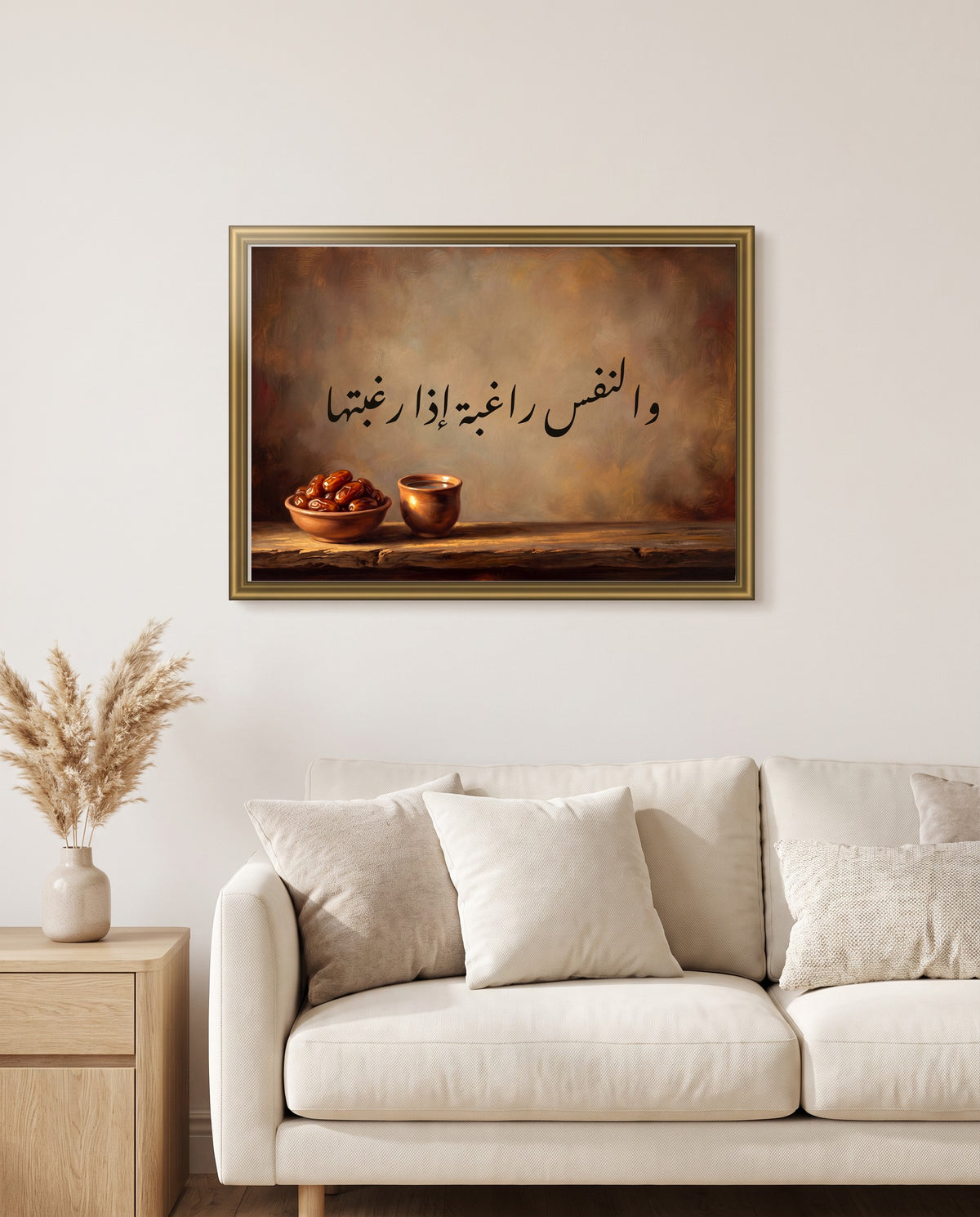 «والنفس راغبة إذا رغبتها» بخط النستعليق في إطار ذهبي مصقول فوق أريكة كريمية في غرفة الجلوس