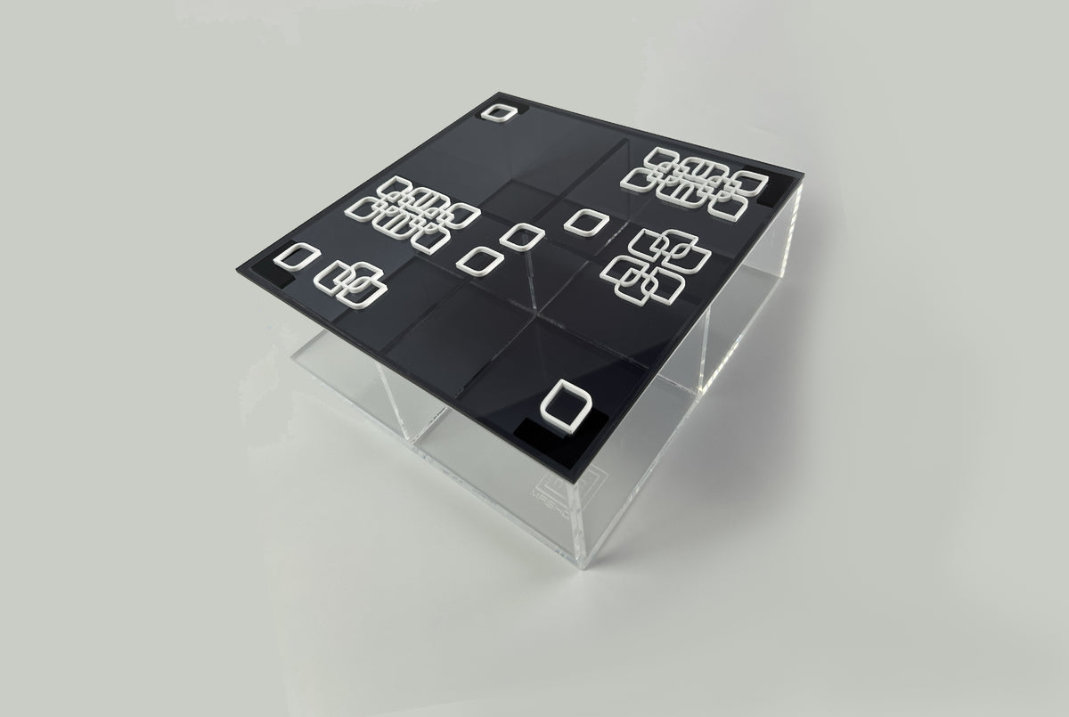 Black lid with white square motifs on a clear acrylic box, viewed from above
