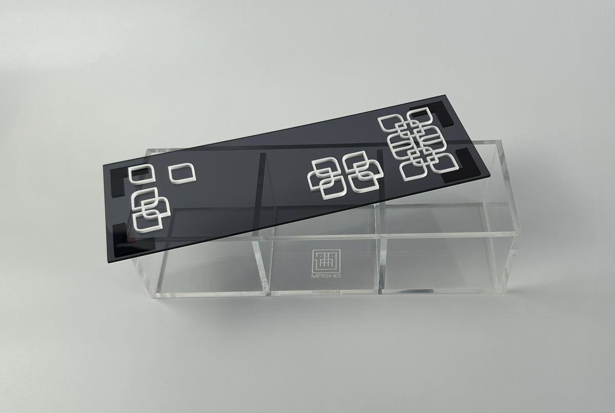 Black patterned lid lifted from a clear divided acrylic nuts box