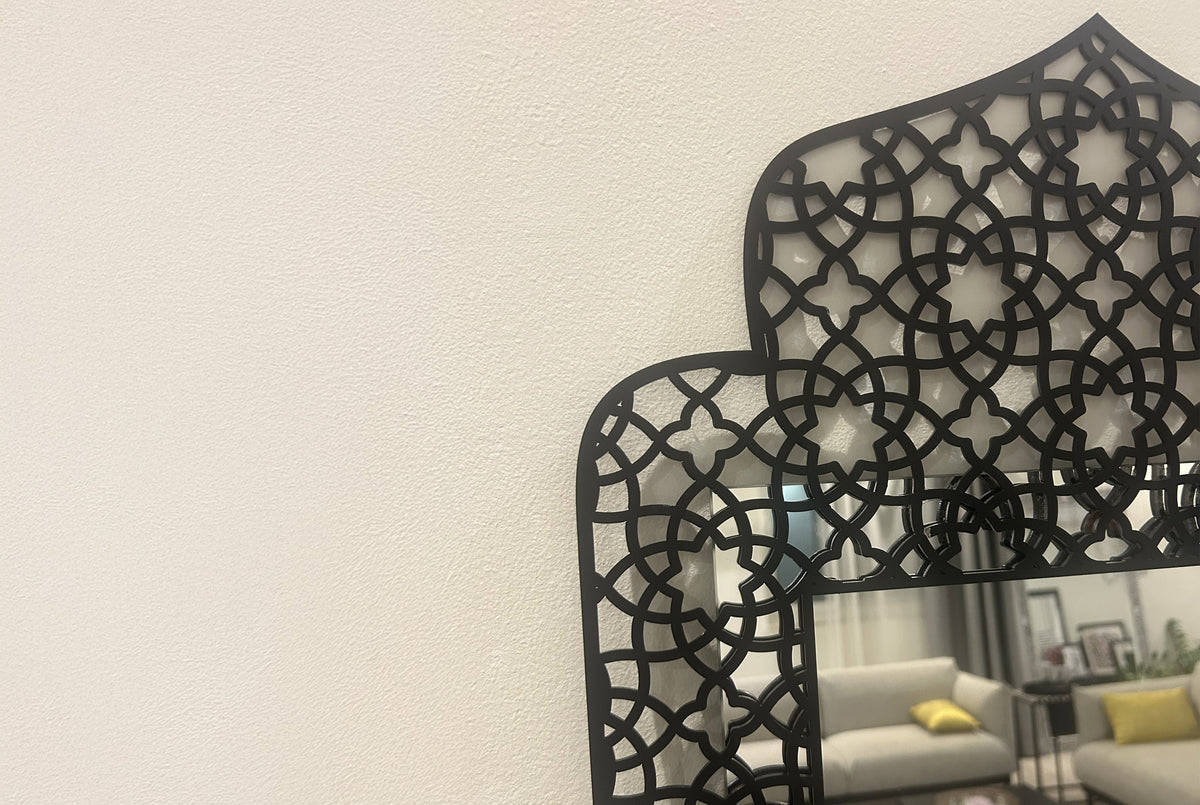 Arabesque mirror frame on a wall, reflecting a sunlit living room