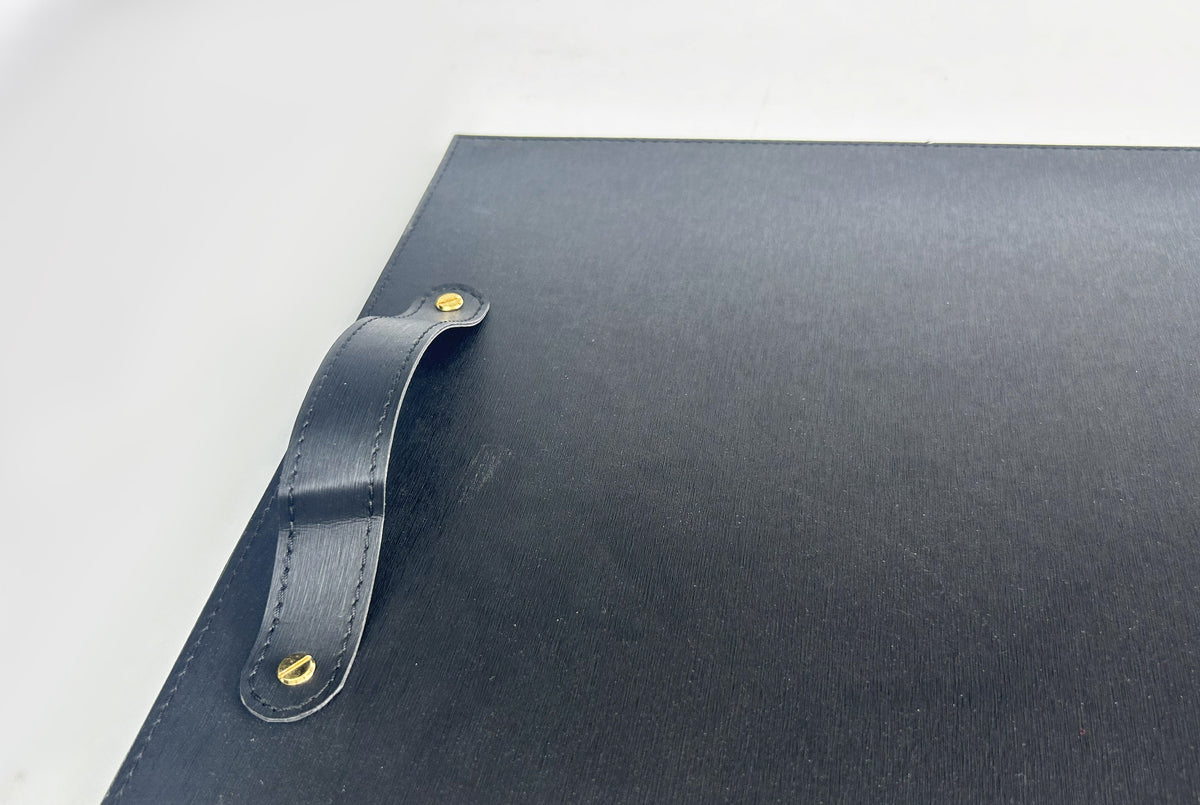Close-up of the stitched leather handle and rivet on the black tray