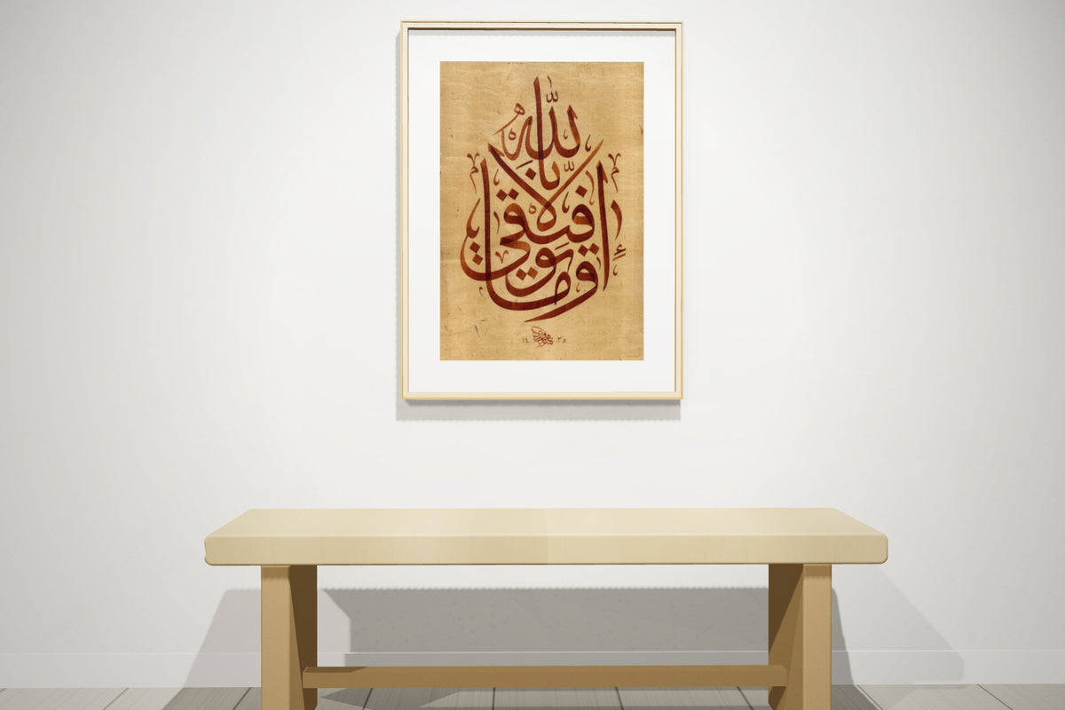 «وما توفيقي إلا بالله» بخط أحمد الهواري، 50 × 70 سم، معروضة بمقاسها الحقيقي في إطار سنديان طبيعي على جدار معرض — التأطير متاح عند الطلب