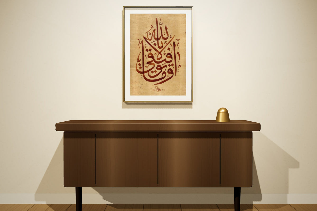 «وما توفيقي إلا بالله» بخط أحمد الهواري، 50 × 70 سم، معروضة بمقاسها الحقيقي في إطار نحاسي رفيع على جدار مجلس — التأطير متاح عند الطلب