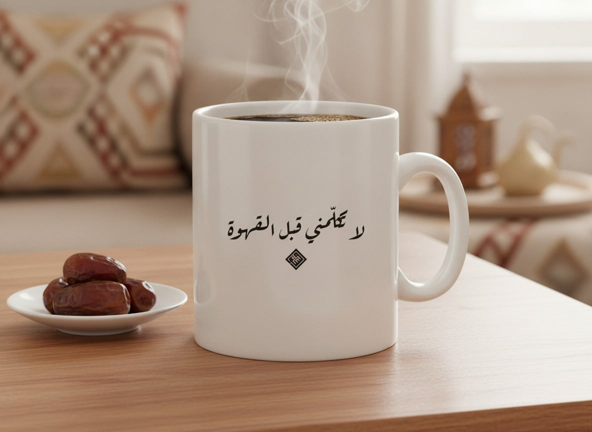 «لا تكلّمني قبل القهوة» Ruq’ah calligraphy mug, filled, on a coffee table