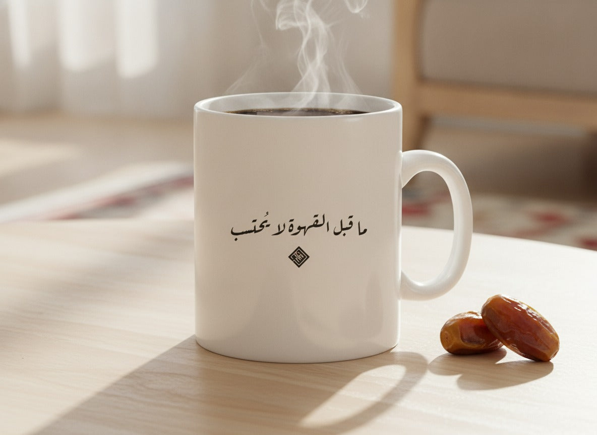 «ما قبل القهوة لا يُحتسب» Ruq’ah calligraphy mug, filled, on a coffee table
