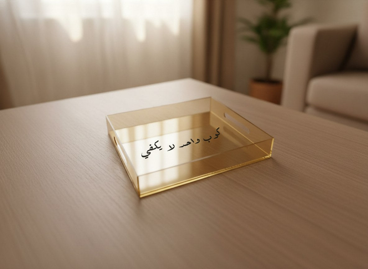 «كوب واحد لا يكفي» Ruq’ah calligraphy serving tray, gold acrylic, on a coffee table