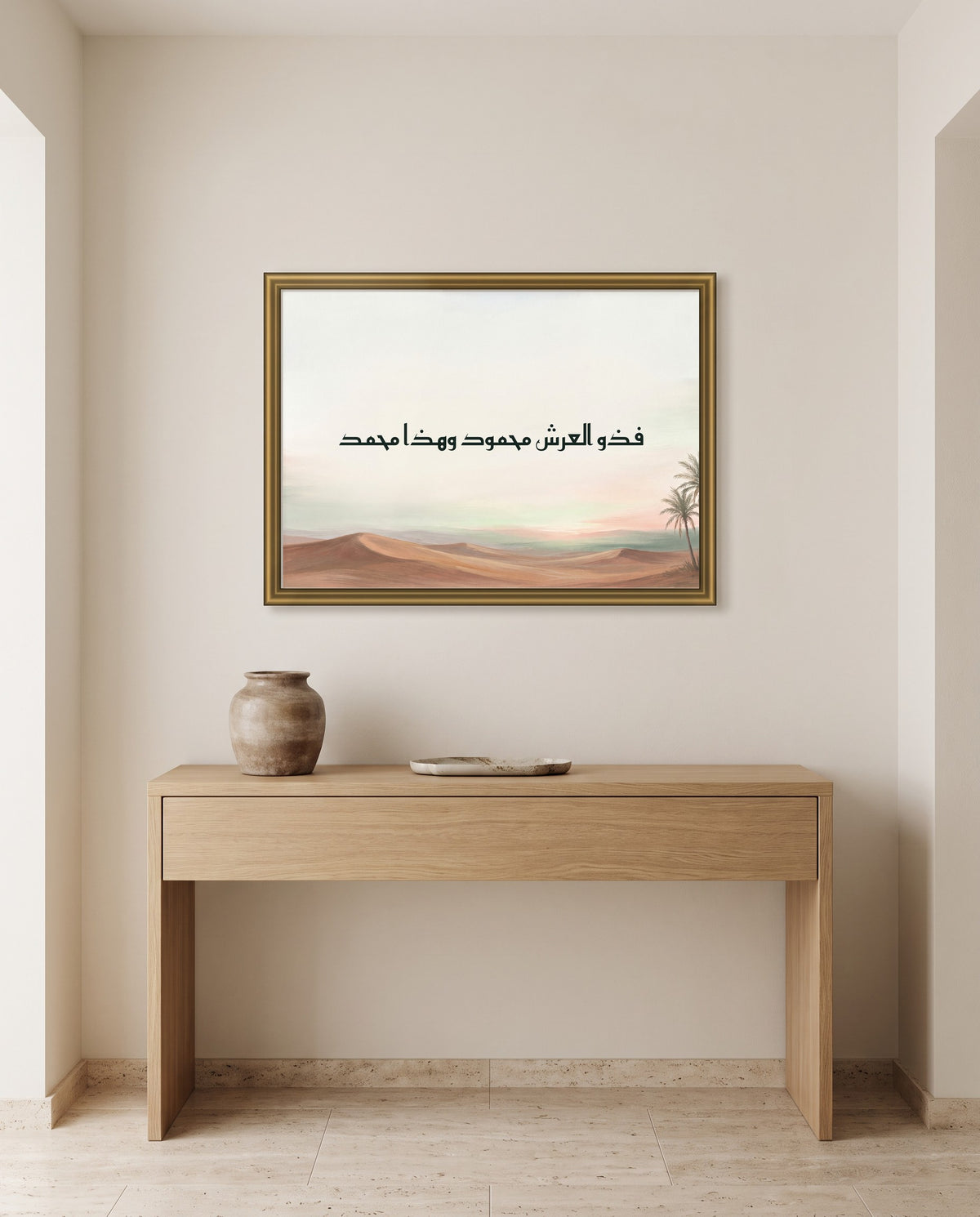 «فذو العرش محمود وهذا محمد» بالخط الكوفي في إطار ذهبي مصقول فوق طاولة كونسول من البلوط في مدخل البيت