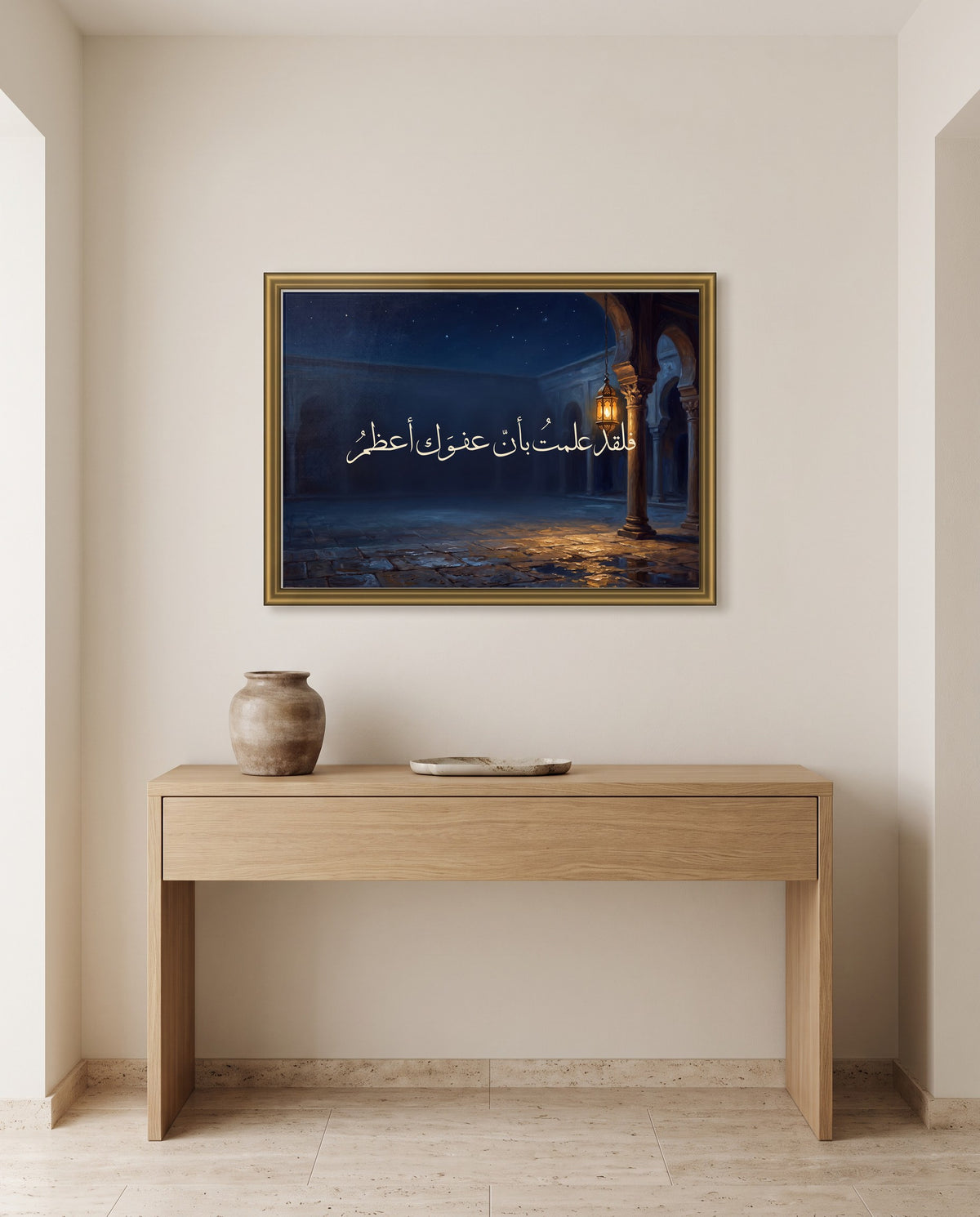 «فلقد علمت بأن عفوك أعظم» بخط الثلث في إطار ذهبي مصقول فوق طاولة كونسول من البلوط في مدخل البيت