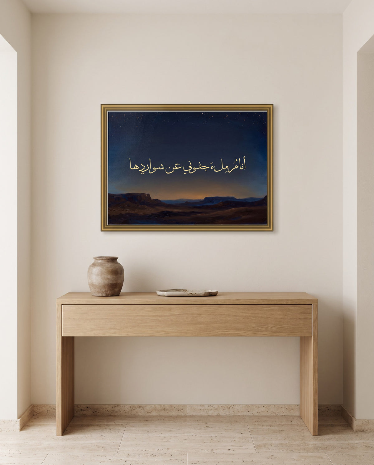 «أنام ملء جفوني عن شواردها» بخط الثلث في إطار ذهبي مصقول فوق طاولة كونسول من البلوط في مدخل البيت