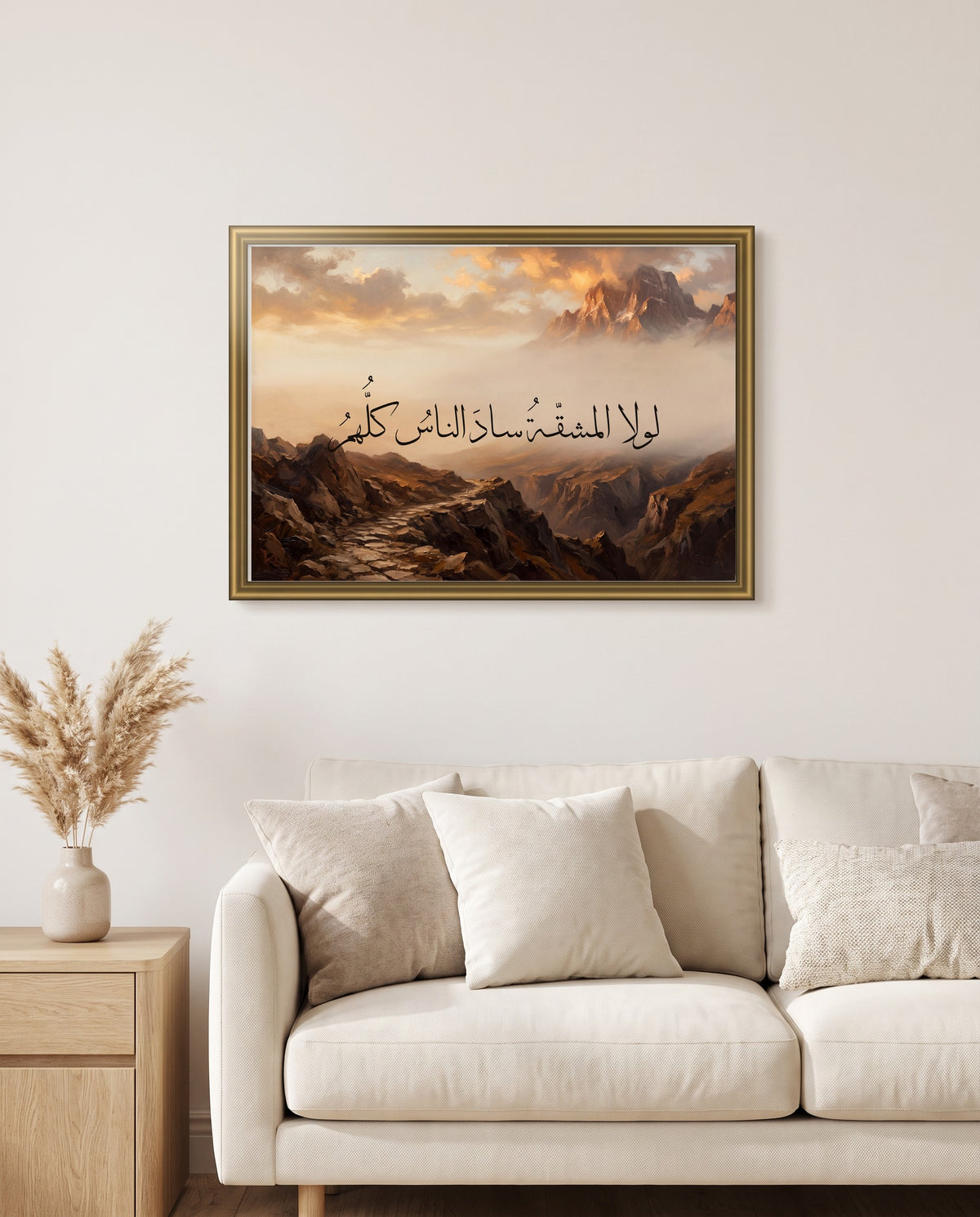 Without Hardship, Everyone Would Lead: Arabic poetry in Thuluth calligraphy, framed in polished gold above a cream sofa in a living room
