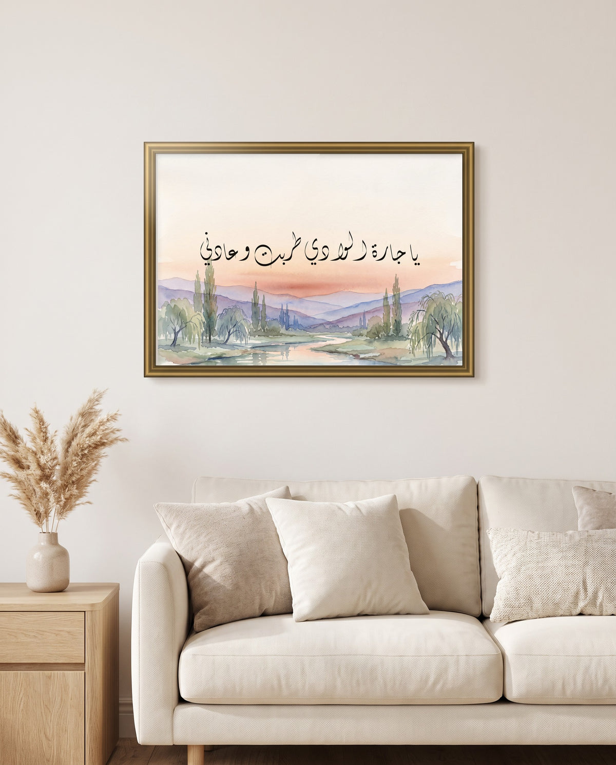 O Neighbour of the Valley: Arabic poetry in Diwani calligraphy, framed in polished gold above a cream sofa in a living room