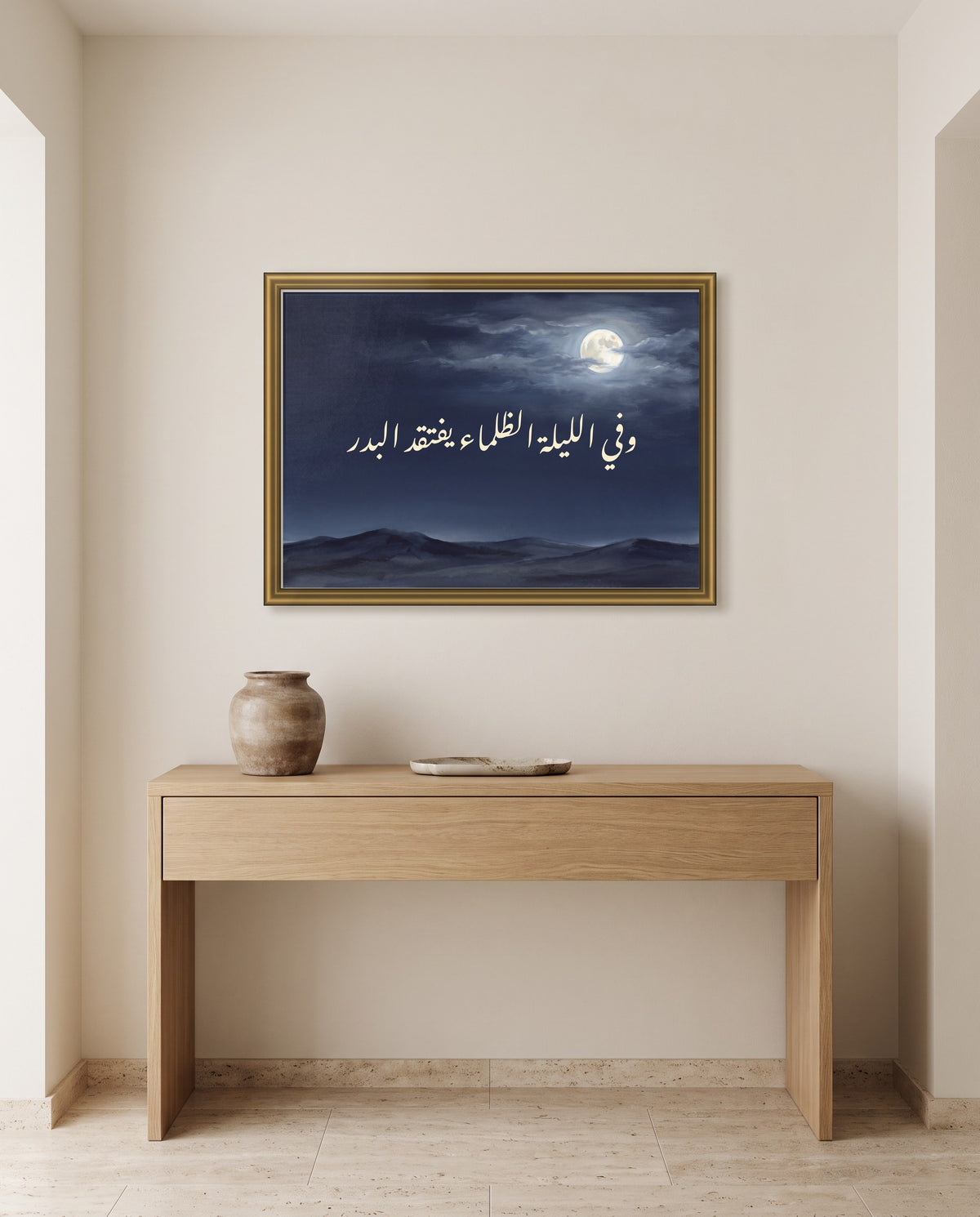 «وفي الليلة الظلماء يفتقد البدر» بخط النستعليق في إطار ذهبي مصقول فوق طاولة كونسول من البلوط في مدخل البيت