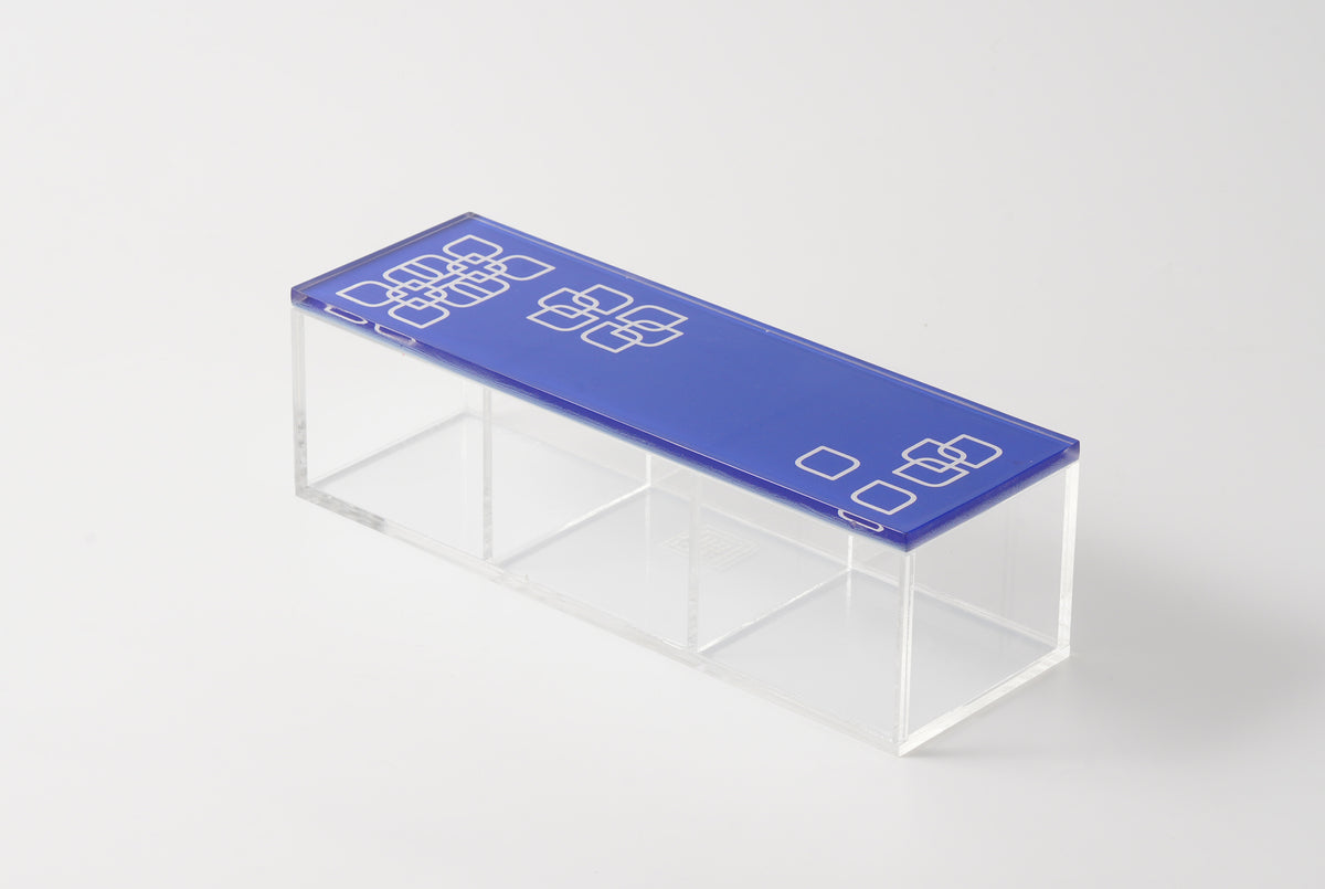 Blue patterned lid on a clear rectangular divided acrylic box