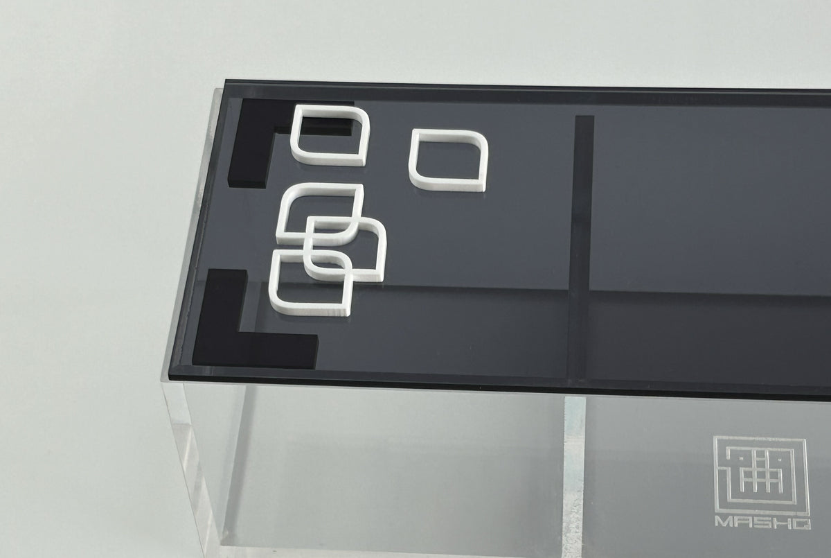 Black lid with white outlined square motifs on a clear divided acrylic box