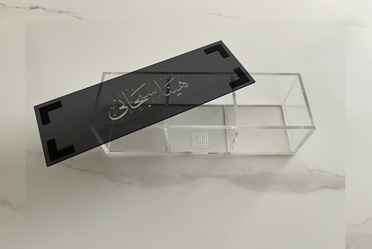 Black Thuluth calligraphy lid lifted from a divided acrylic box