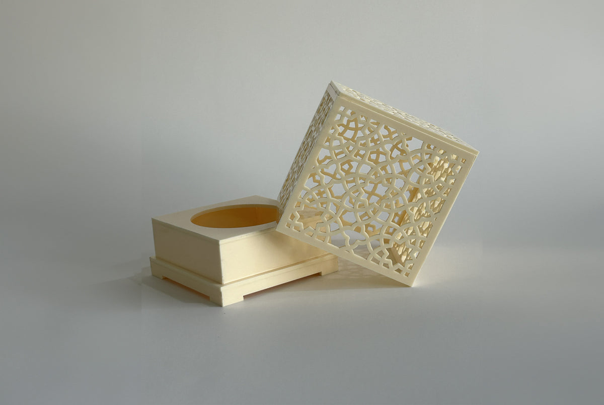 Cream pierced arabesque censer with the lid tilted against the base