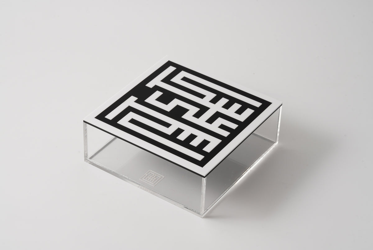 Clear acrylic box with a black square-Kufic lid, seen from above at an angle