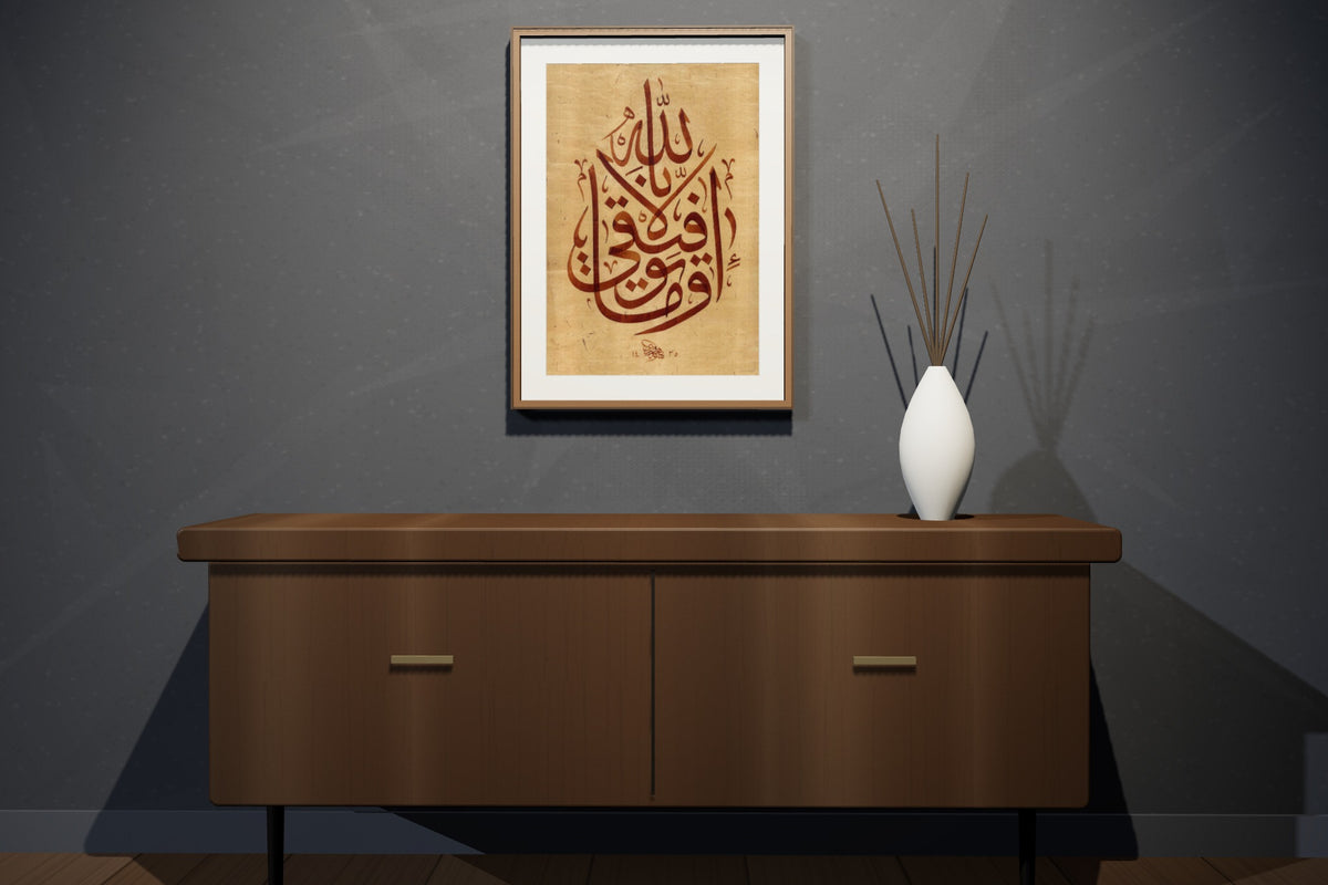 «وما توفيقي إلا بالله» بخط أحمد الهواري، 50 × 70 سم، معروضة بمقاسها الحقيقي في إطار جوز داكن في شقة علوية — التأطير متاح عند الطلب